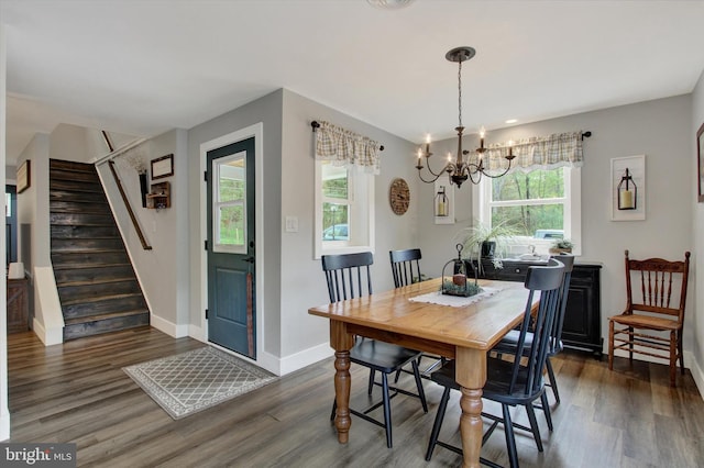 dining room with an inviting chandelier, baseboards, stairs, and dark wood-type flooring