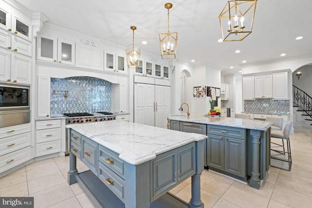 696 Miller Ave, Great Falls, VA 22066 - kitchen featuring a large island with sink, a chandelier, backsplash, black microwave, and white cabinets