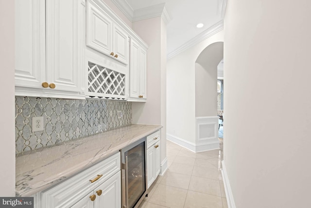 696 Miller Ave, Great Falls, VA 22066 - bar with a dry bar, crown molding, arched walkways, light tile patterned floors, and beverage cooler