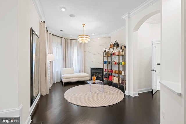 696 Miller Ave, Great Falls, VA 22066 - living area featuring a notable chandelier, ornamental molding, a glass covered fireplace, and dark wood-style floors
