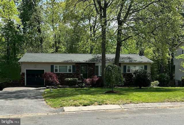 ranch-style house with a chimney, a garage, brick siding, aphalt driveway, and a front lawn