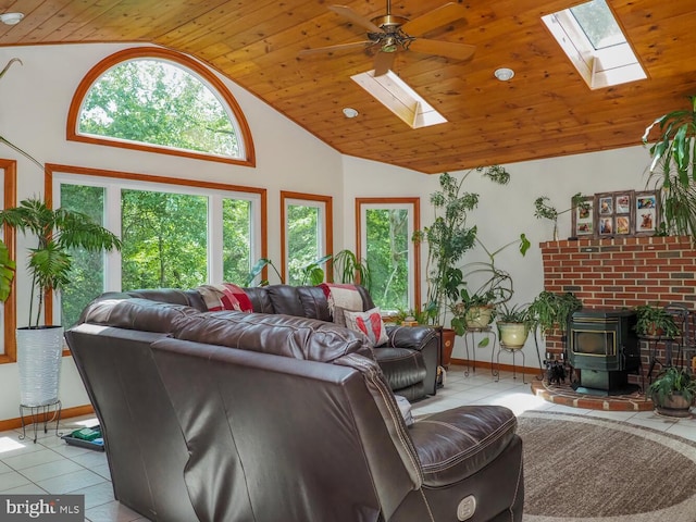 1235 Lorene Dr, Pasadena, MD 21122 - living area featuring a skylight, a wood stove, wooden ceiling, tile patterned floors, and healthy amount of natural light