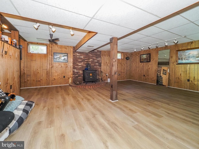 1235 Lorene Dr, Pasadena, MD 21122 - unfurnished living room with wooden walls, rail lighting, a wood stove, and wood finished floors