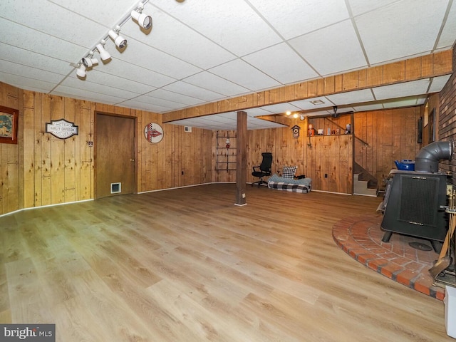 1235 Lorene Dr, Pasadena, MD 21122 - unfurnished living room featuring a wood stove, wood walls, wood finished floors, track lighting, and stairway