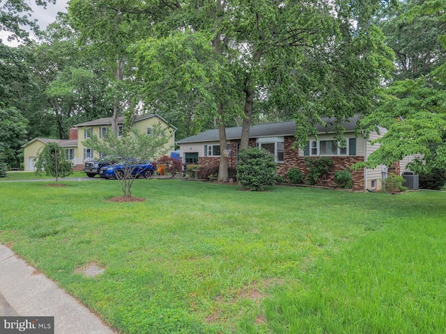 1235 Lorene Dr, Pasadena, MD 21122 - view of front of house with brick siding, a front yard, central AC, and view of scattered trees