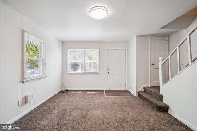 entryway featuring stairway, baseboards, and carpet