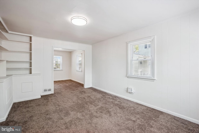 interior space featuring baseboards, carpet, and visible vents