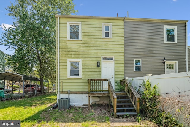 back of house featuring fence, central AC unit, and a carport