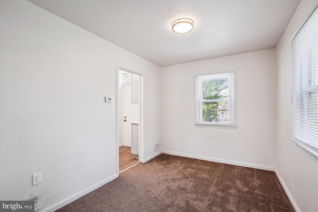 unfurnished room featuring baseboards, carpet, and visible vents