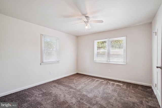 carpeted spare room featuring plenty of natural light, baseboards, and ceiling fan