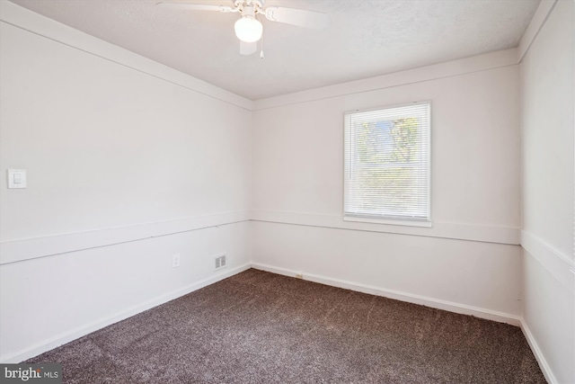 carpeted spare room with baseboards, ceiling fan, and visible vents