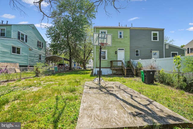 back of house featuring a detached carport and fence