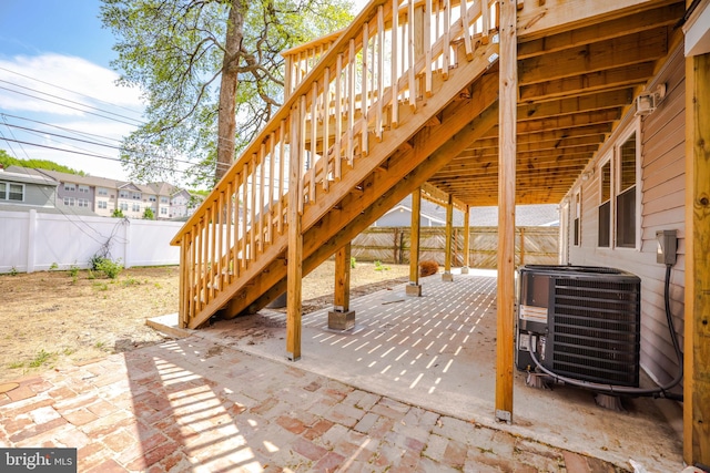 view of patio / terrace featuring a fenced backyard, central AC, and stairway