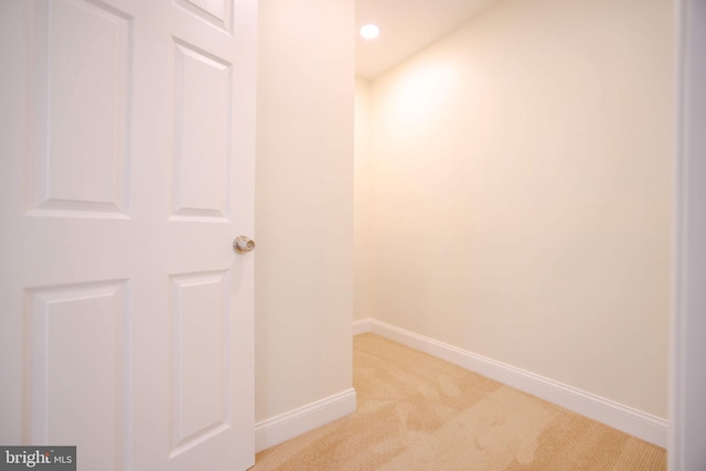 hallway featuring baseboards, recessed lighting, and light colored carpet