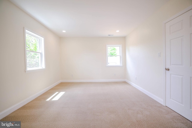 empty room featuring baseboards, light carpet, and recessed lighting