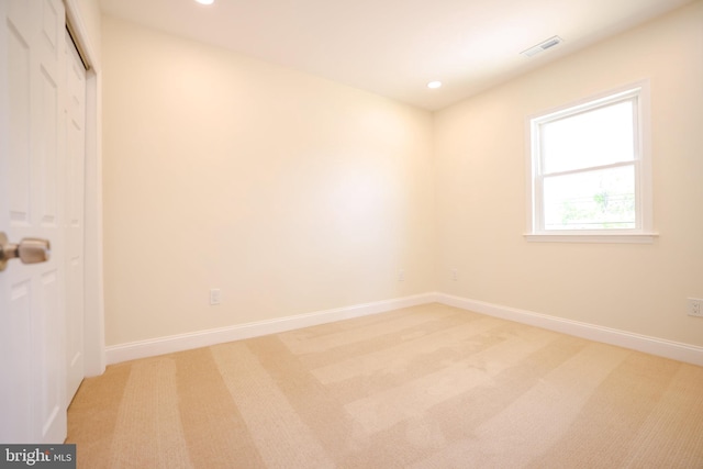 empty room featuring baseboards, visible vents, recessed lighting, and light colored carpet