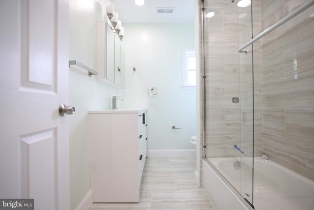 full bathroom with shower / bath combination with glass door, vanity, toilet, baseboards, and visible vents
