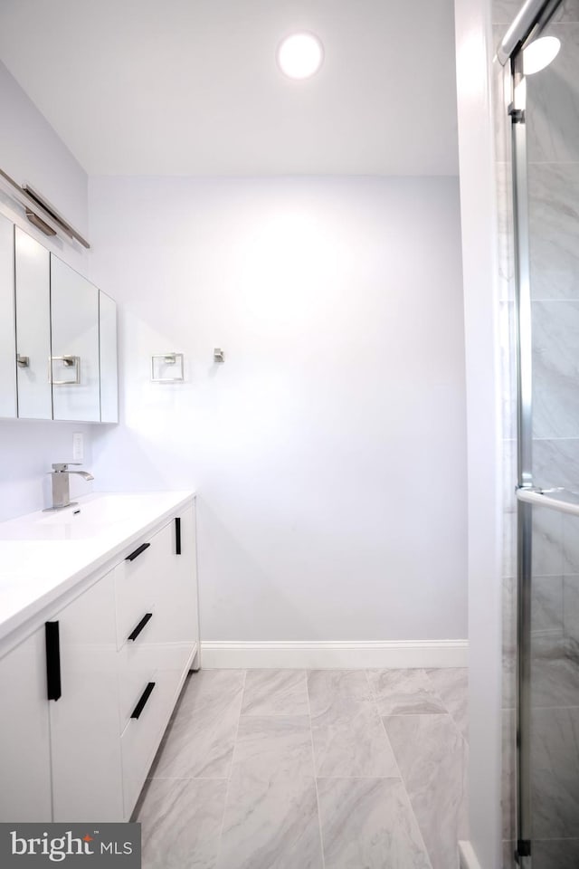 full bath featuring vanity, baseboards, marble finish floor, a shower with door, and recessed lighting