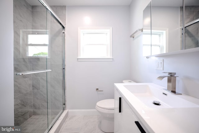 bathroom with baseboards, a stall shower, toilet, and vanity