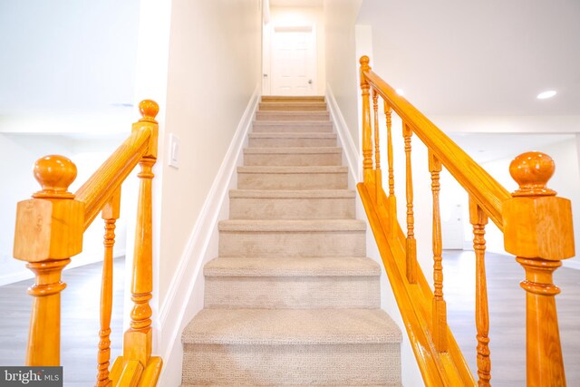 staircase featuring baseboards and recessed lighting