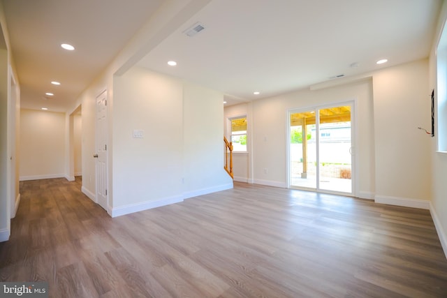 spare room with stairs, recessed lighting, wood finished floors, and visible vents