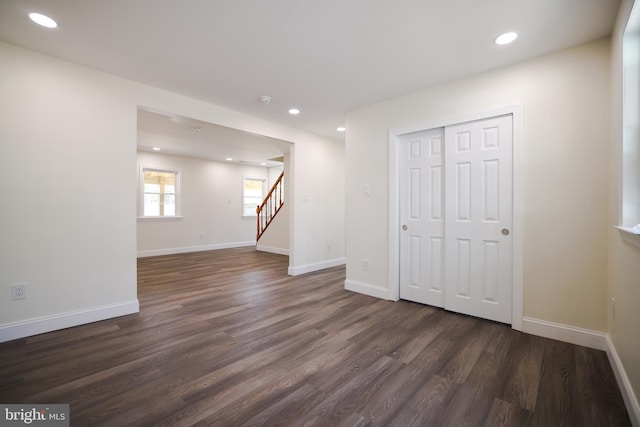basement featuring recessed lighting, baseboards, dark wood finished floors, and stairs