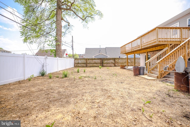 view of yard featuring stairs, a fenced backyard, and a wooden deck