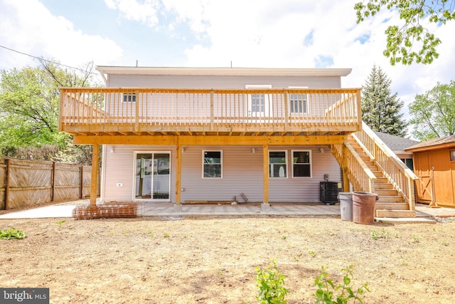 rear view of house featuring stairs, a patio area, fence, and a deck
