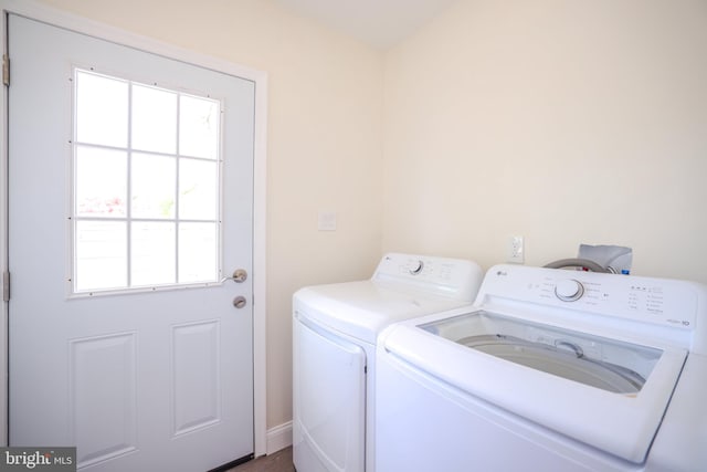 laundry room featuring baseboards, separate washer and dryer, laundry area, and a wealth of natural light