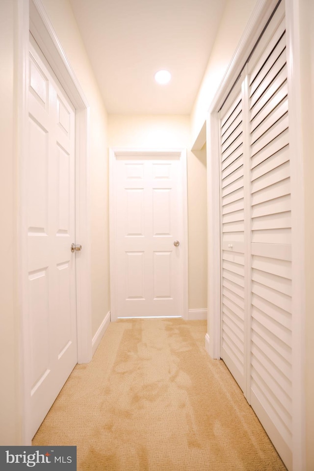 corridor with baseboards, recessed lighting, and light colored carpet