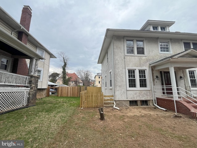 3314 Egerton Rd, Baltimore, MD 21215 - view of property exterior with a lawn, fence, and stucco siding