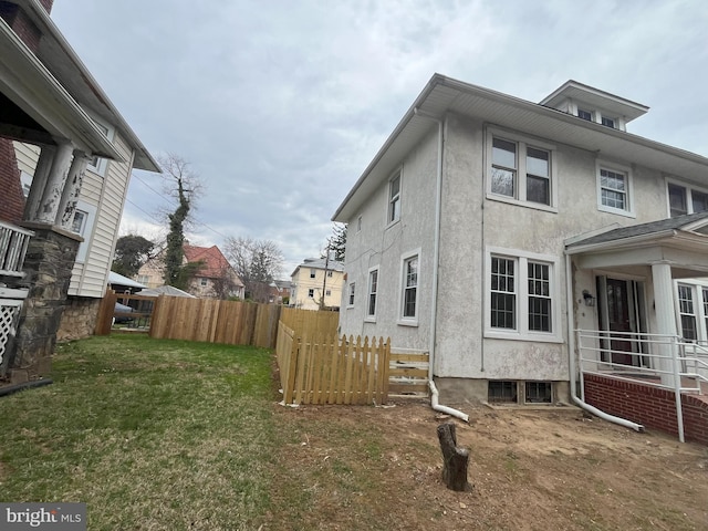 3314 Egerton Rd, Baltimore, MD 21215 - view of property exterior featuring a lawn, stucco siding, and fence