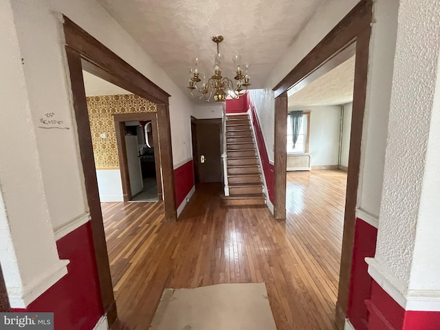 3314 Egerton Rd, Baltimore, MD 21215 - unfurnished dining area featuring a chandelier, a wainscoted wall, stairway, and hardwood / wood-style floors