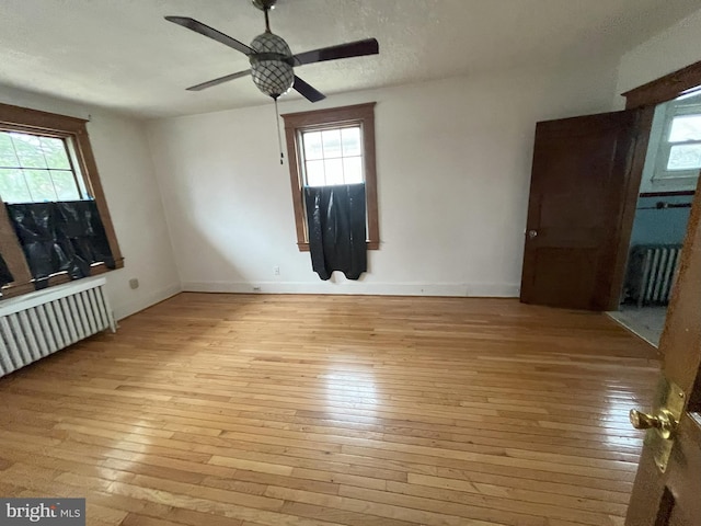 3314 Egerton Rd, Baltimore, MD 21215 - unfurnished bedroom with radiator, multiple windows, and hardwood / wood-style flooring