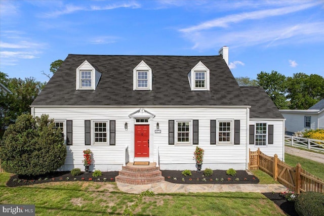 cape cod home featuring a shingled roof, a front lawn, fence, and a chimney