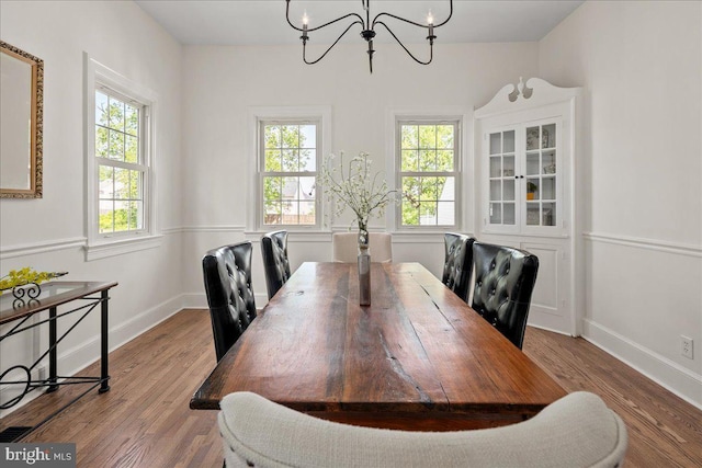 dining room with baseboards, wood finished floors, and a chandelier