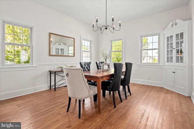dining room with light wood-style floors, a notable chandelier, and a healthy amount of sunlight