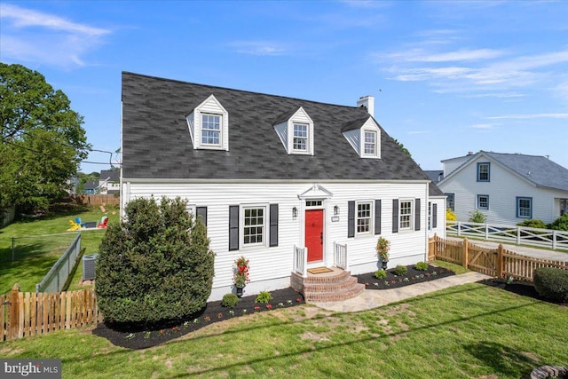 cape cod home with a chimney, a fenced backyard, a front yard, and a shingled roof