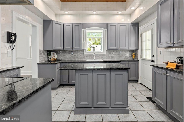 kitchen featuring gray cabinetry, light tile patterned floors, and a sink