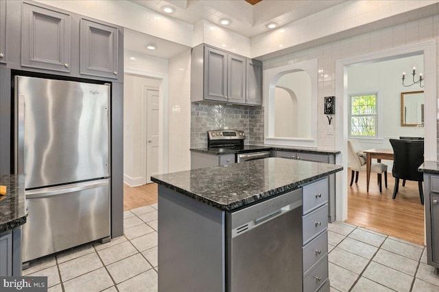 kitchen with light tile patterned floors, a center island, gray cabinets, and stainless steel appliances