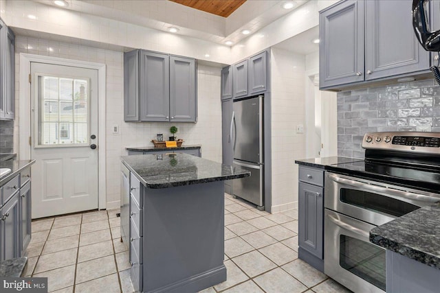 kitchen with stainless steel appliances, gray cabinetry, light tile patterned flooring, and tasteful backsplash