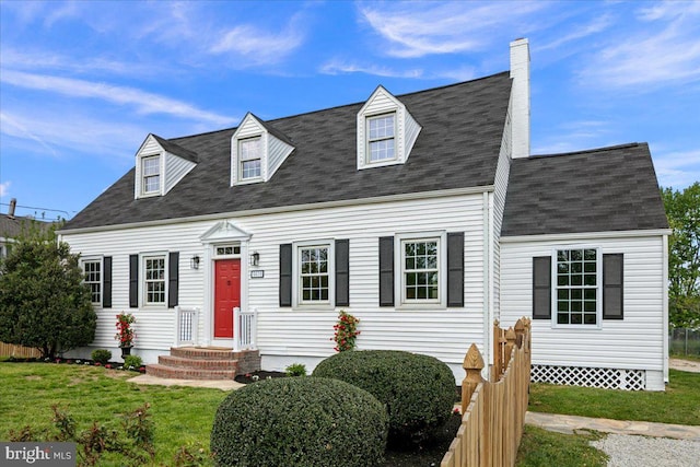 cape cod house featuring roof with shingles, a chimney, and a front yard