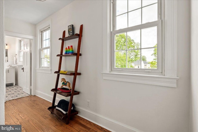 corridor with baseboards and wood finished floors