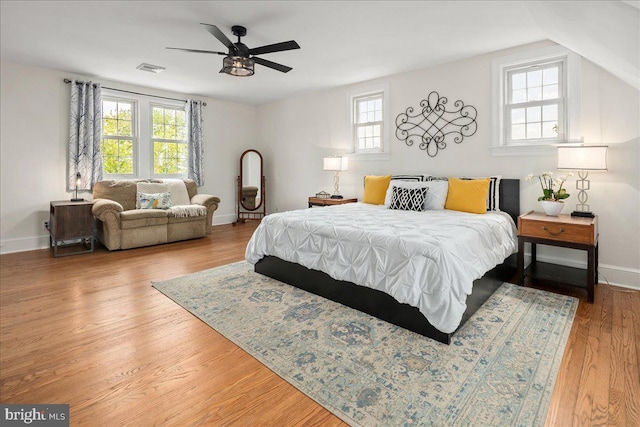bedroom with baseboards, a ceiling fan, wood finished floors, and visible vents