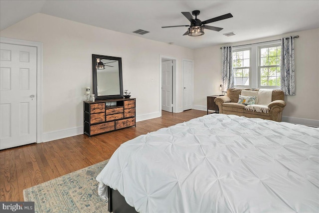 bedroom with baseboards, visible vents, and wood finished floors