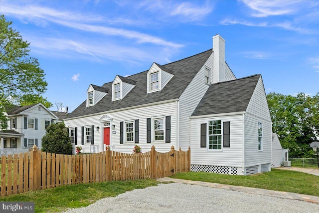 cape cod house featuring roof with shingles, a fenced front yard, and a chimney
