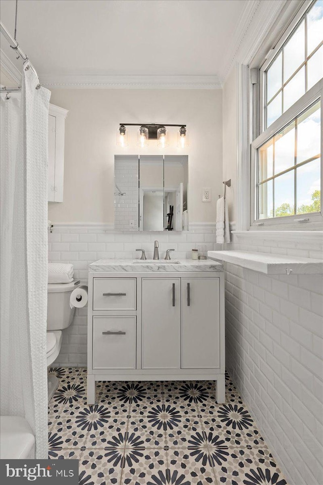 bathroom with crown molding, vanity, toilet, tile walls, and a shower with shower curtain