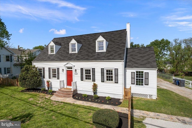 cape cod home with roof with shingles, fence, a chimney, and a front yard