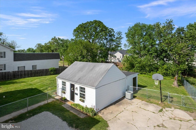 view of outdoor structure with a gate, a fenced backyard, an outbuilding, and central AC unit