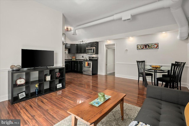 living area with baseboards and dark wood-type flooring